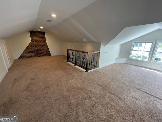 additional living space with vaulted ceiling and carpet floors