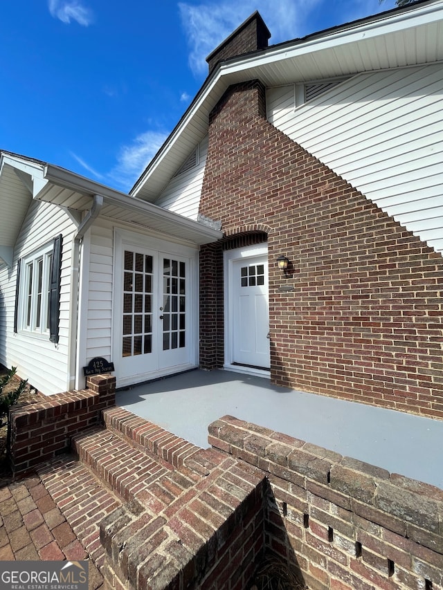 entrance to property featuring french doors and a patio area