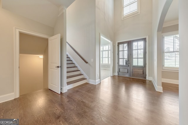 entrance foyer with a high ceiling, dark hardwood / wood-style floors, and french doors