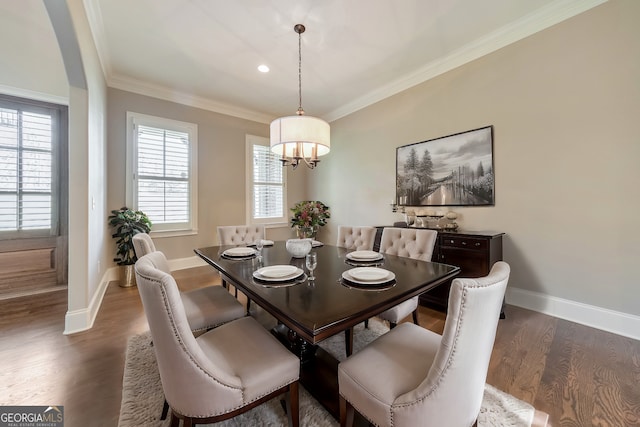 dining area with a healthy amount of sunlight, dark hardwood / wood-style flooring, crown molding, and a chandelier