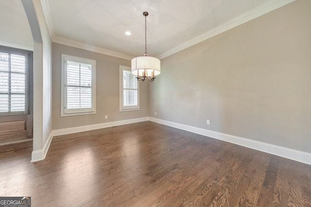 unfurnished dining area with dark hardwood / wood-style flooring, ornamental molding, a wealth of natural light, and an inviting chandelier