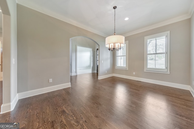 spare room with a chandelier, dark hardwood / wood-style floors, and ornamental molding