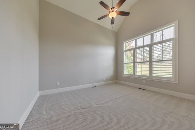 empty room featuring light colored carpet, high vaulted ceiling, and ceiling fan