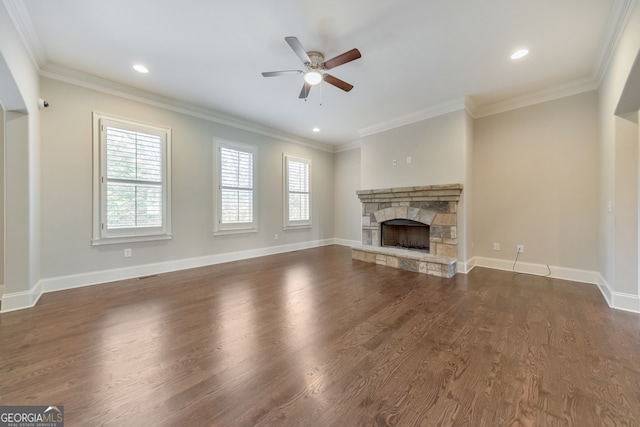 unfurnished living room with dark hardwood / wood-style flooring, a stone fireplace, and ornamental molding