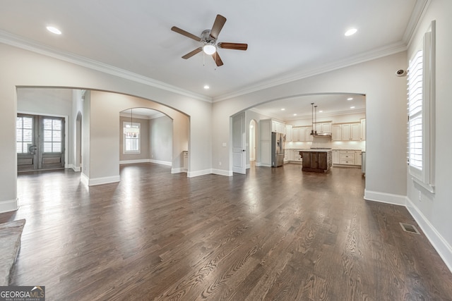 unfurnished living room with ceiling fan, ornamental molding, dark wood-type flooring, and french doors