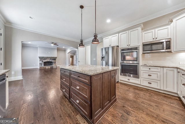 kitchen featuring pendant lighting, ceiling fan, dark hardwood / wood-style floors, appliances with stainless steel finishes, and dark brown cabinets