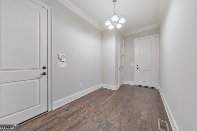 foyer featuring ornamental molding, an inviting chandelier, and dark wood-type flooring