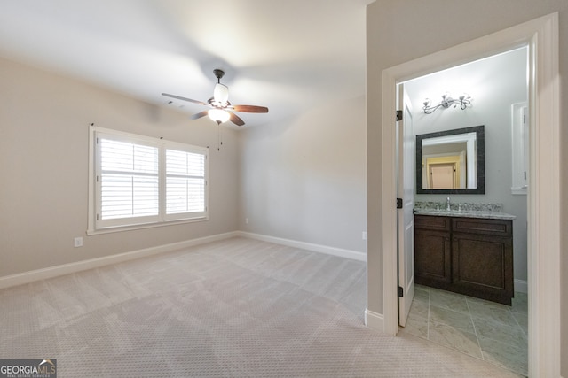 carpeted empty room featuring ceiling fan and sink