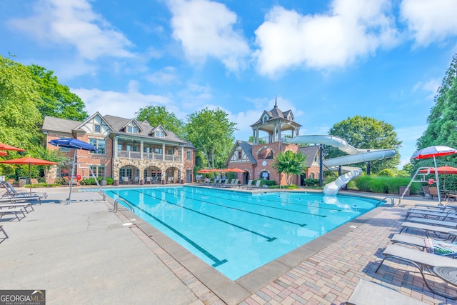 view of swimming pool with a patio and a water slide