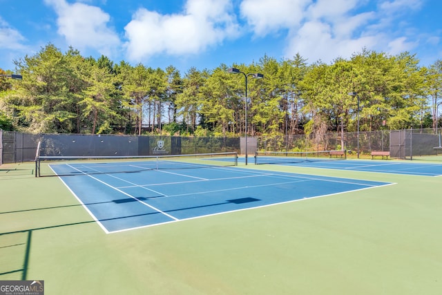 view of tennis court with basketball hoop