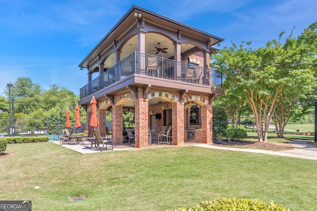 view of front of house with a front lawn, a patio, a balcony, and ceiling fan