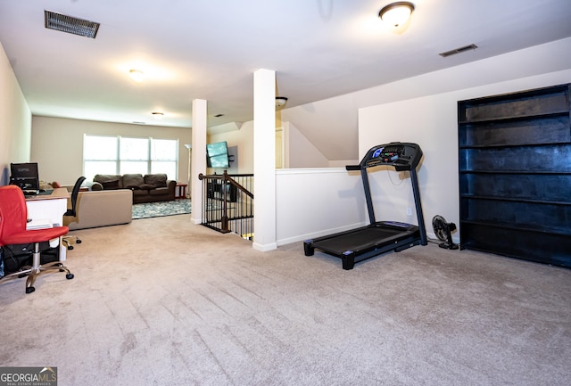 exercise room featuring vaulted ceiling and light carpet