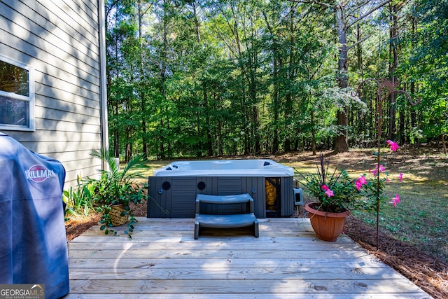 wooden deck featuring a hot tub and a grill