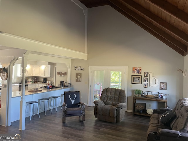 living room featuring dark hardwood / wood-style flooring, beamed ceiling, wooden ceiling, and high vaulted ceiling