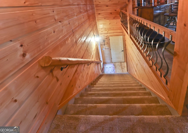 stairway featuring wooden walls