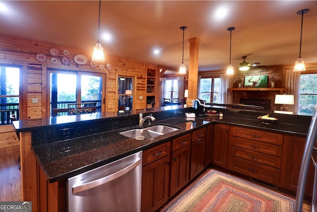 kitchen with sink, decorative light fixtures, dark stone counters, and dishwasher