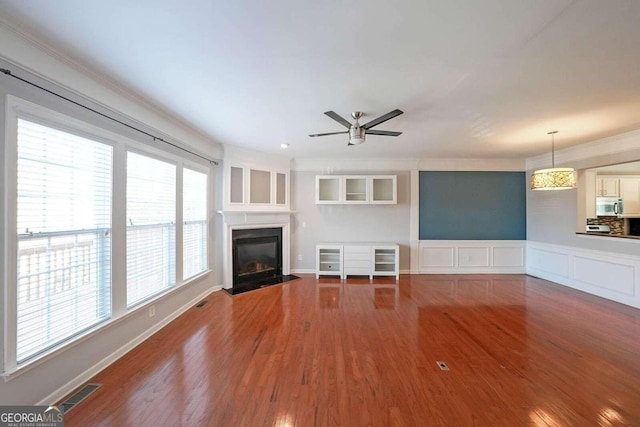 unfurnished living room featuring ceiling fan and hardwood / wood-style floors