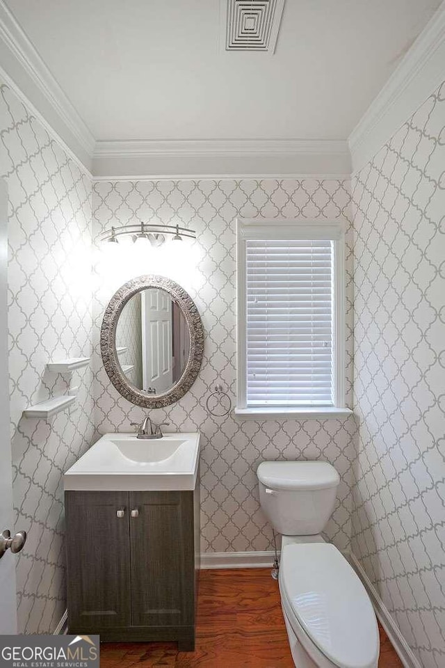 bathroom featuring vanity, toilet, hardwood / wood-style flooring, and crown molding