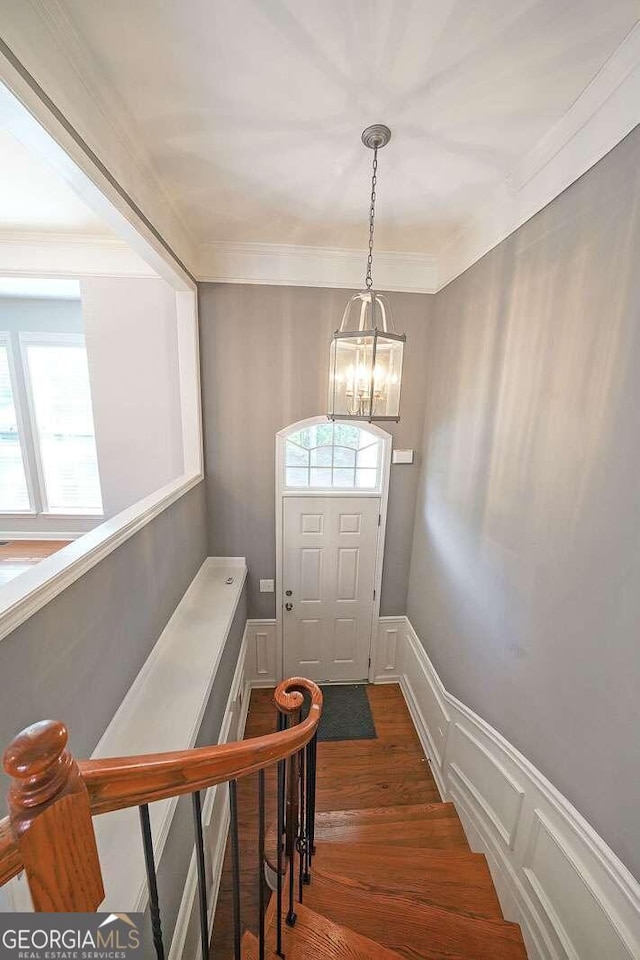 interior space featuring ornamental molding, a chandelier, and wood-type flooring