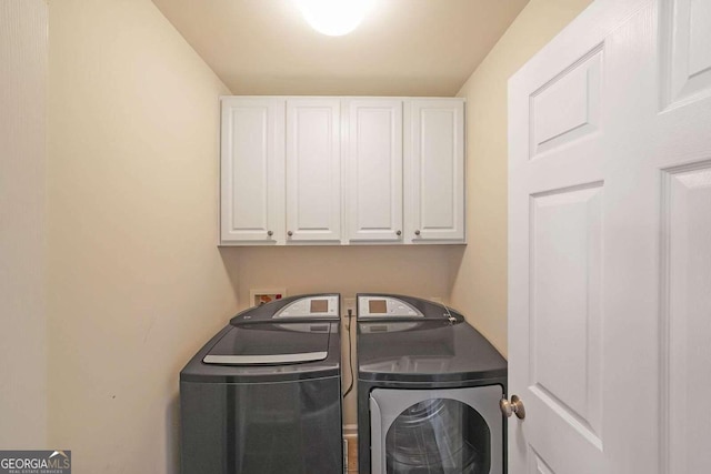 washroom with washing machine and dryer and cabinets