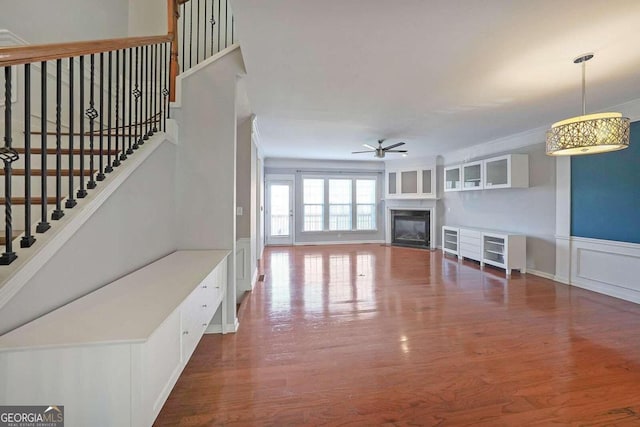 unfurnished living room with dark wood-type flooring and ceiling fan