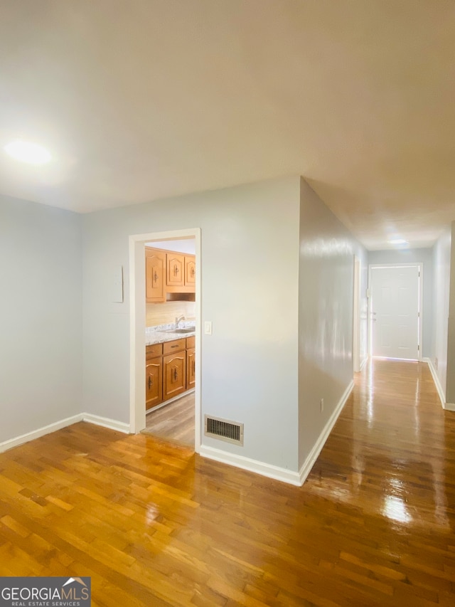 corridor with sink and light wood-type flooring