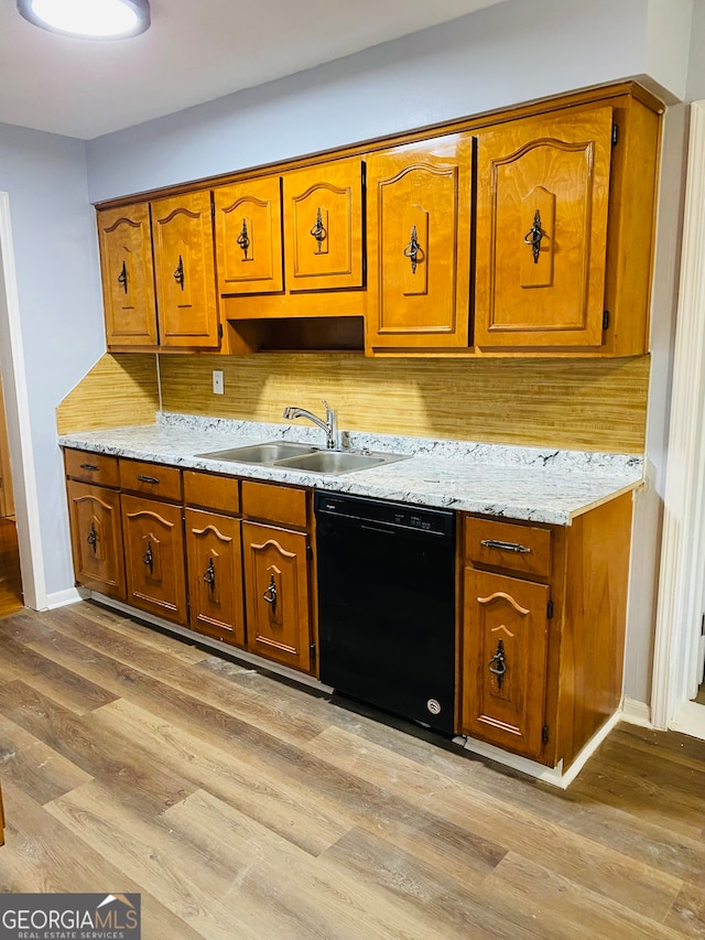 kitchen featuring light hardwood / wood-style flooring, dishwasher, and tasteful backsplash