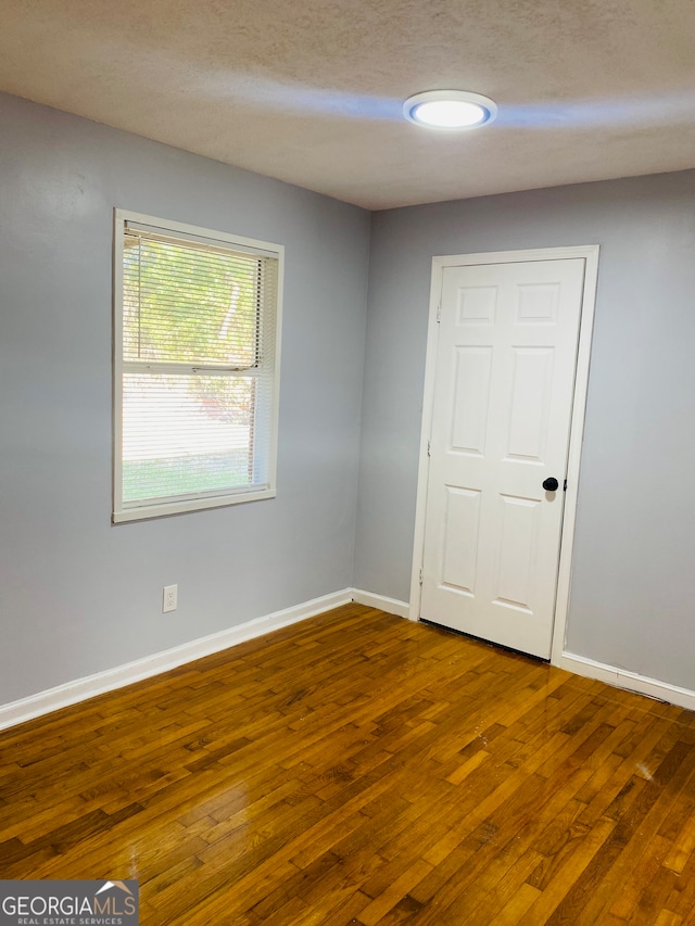 spare room with hardwood / wood-style floors and a textured ceiling