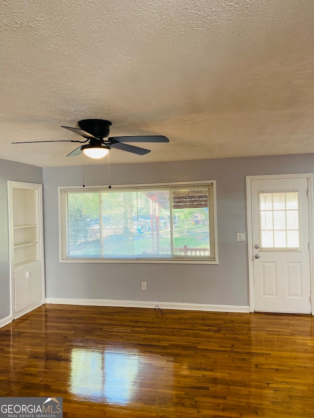 interior space featuring a textured ceiling, dark hardwood / wood-style floors, and a healthy amount of sunlight