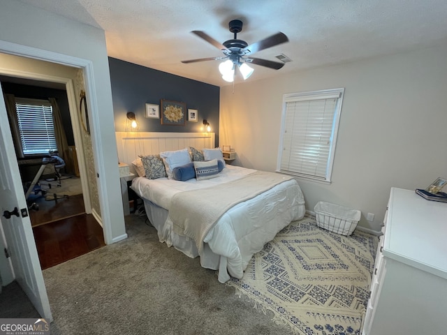 carpeted bedroom with a textured ceiling and ceiling fan