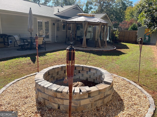 back of property featuring a patio, a gazebo, a yard, and a fire pit