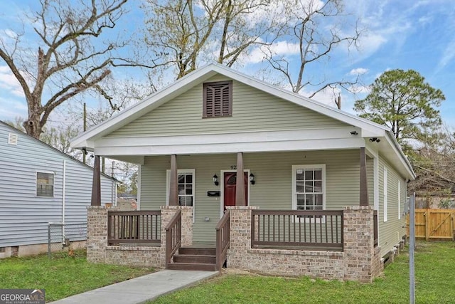 bungalow featuring a porch and a front lawn