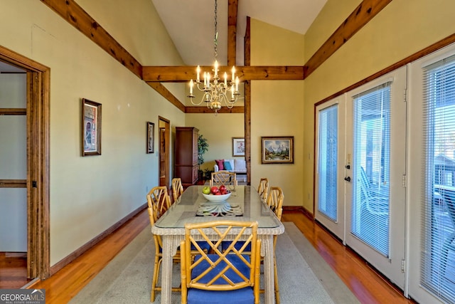 dining room with an inviting chandelier, french doors, lofted ceiling with beams, and light wood-type flooring