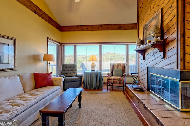 living room with hardwood / wood-style flooring, vaulted ceiling, and a tile fireplace