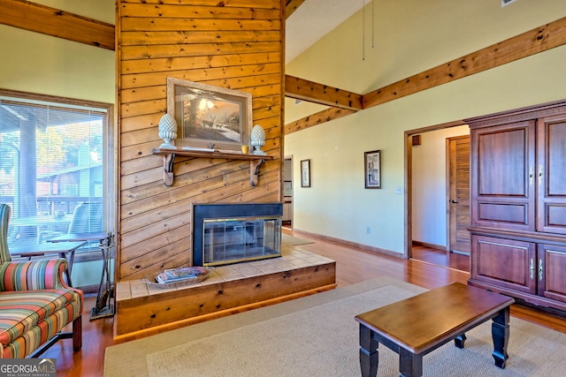 living room with vaulted ceiling, light hardwood / wood-style flooring, and a tile fireplace