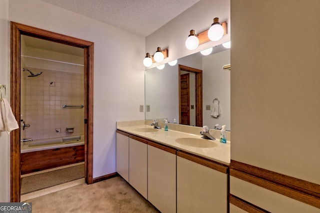 bathroom featuring vanity, tiled shower / bath combo, and a textured ceiling