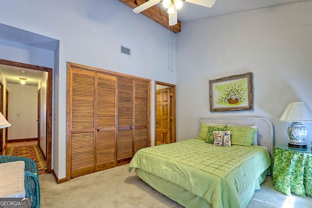 bedroom featuring a closet, light colored carpet, high vaulted ceiling, and ceiling fan