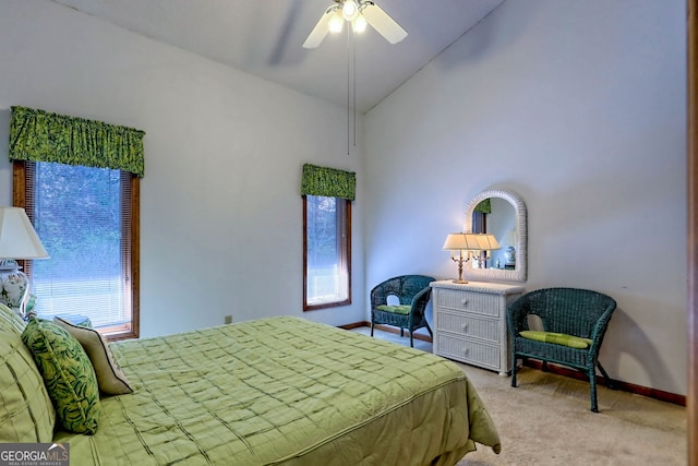 bedroom featuring multiple windows, light colored carpet, high vaulted ceiling, and ceiling fan