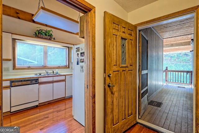 interior space featuring sink, light hardwood / wood-style flooring, and a textured ceiling