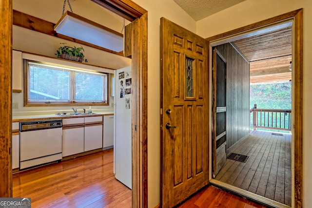 hall featuring light hardwood / wood-style floors, a textured ceiling, and sink