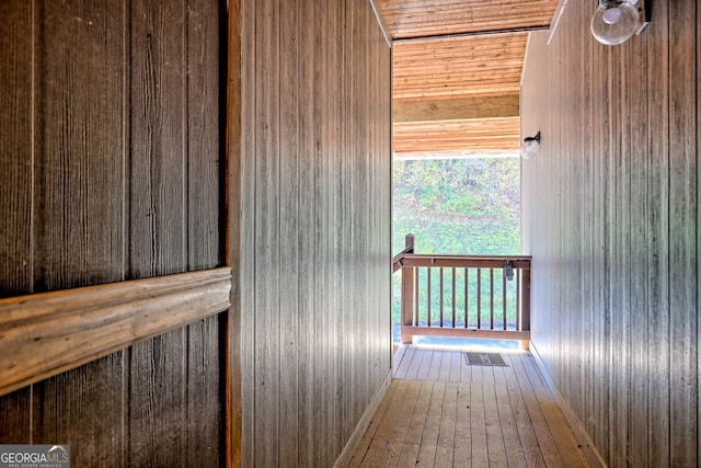 interior space featuring hardwood / wood-style flooring, wooden walls, and wooden ceiling