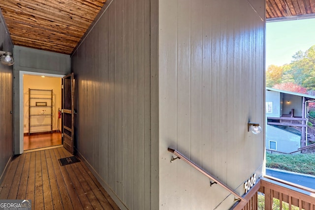 hall featuring wood ceiling, wood walls, and wood-type flooring