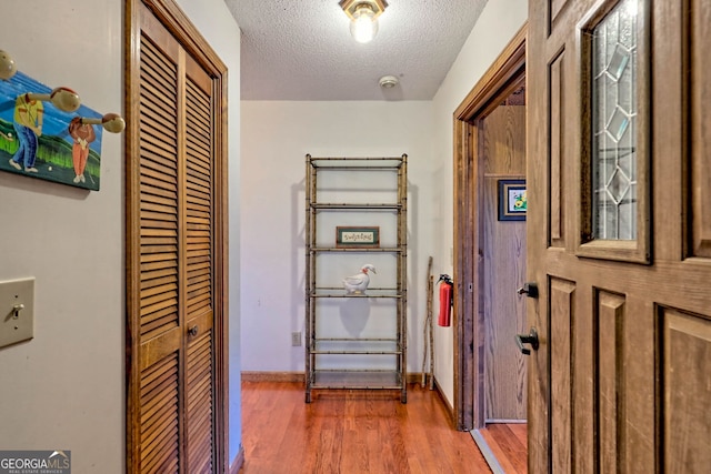 hall with dark wood-type flooring and a textured ceiling