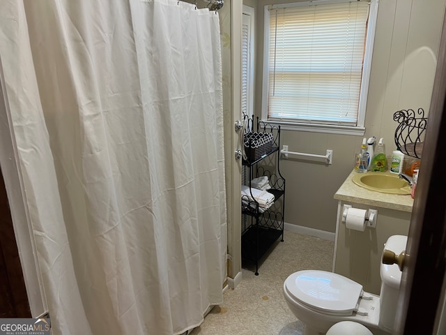 bathroom featuring vanity, curtained shower, and toilet