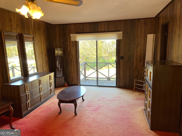 living area with wooden walls and light colored carpet