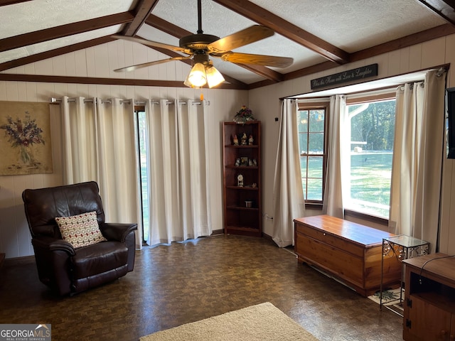 sitting room featuring a textured ceiling, lofted ceiling with beams, and ceiling fan