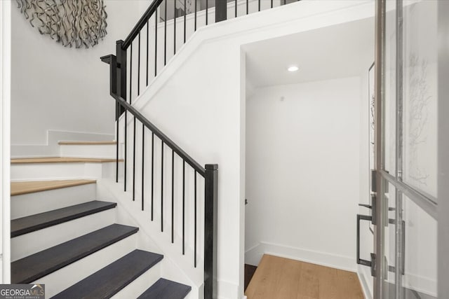 staircase with hardwood / wood-style floors