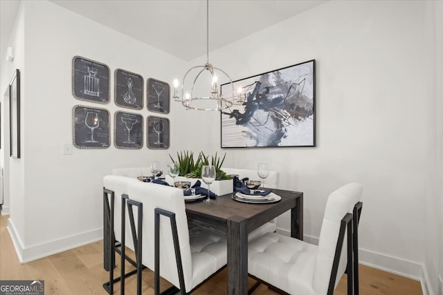 dining room featuring wood-type flooring and an inviting chandelier