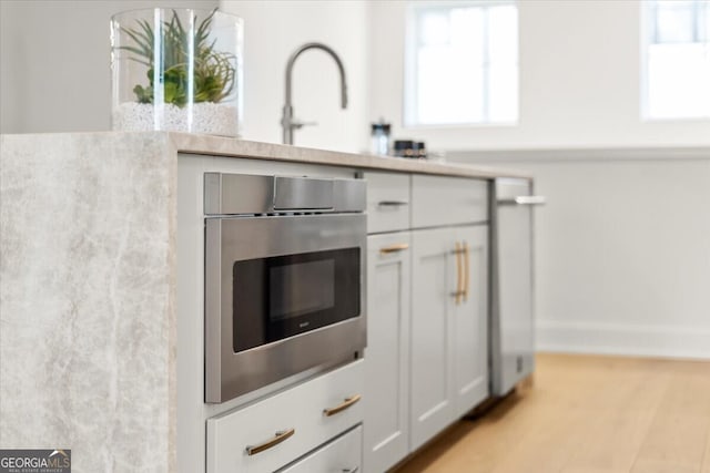 kitchen featuring stainless steel oven and light wood-type flooring