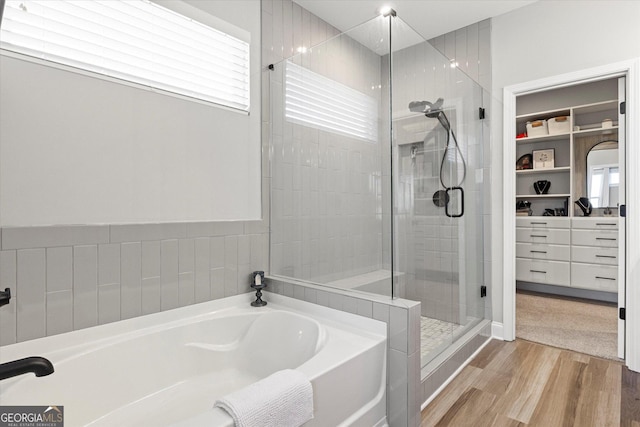 bathroom with independent shower and bath and hardwood / wood-style flooring